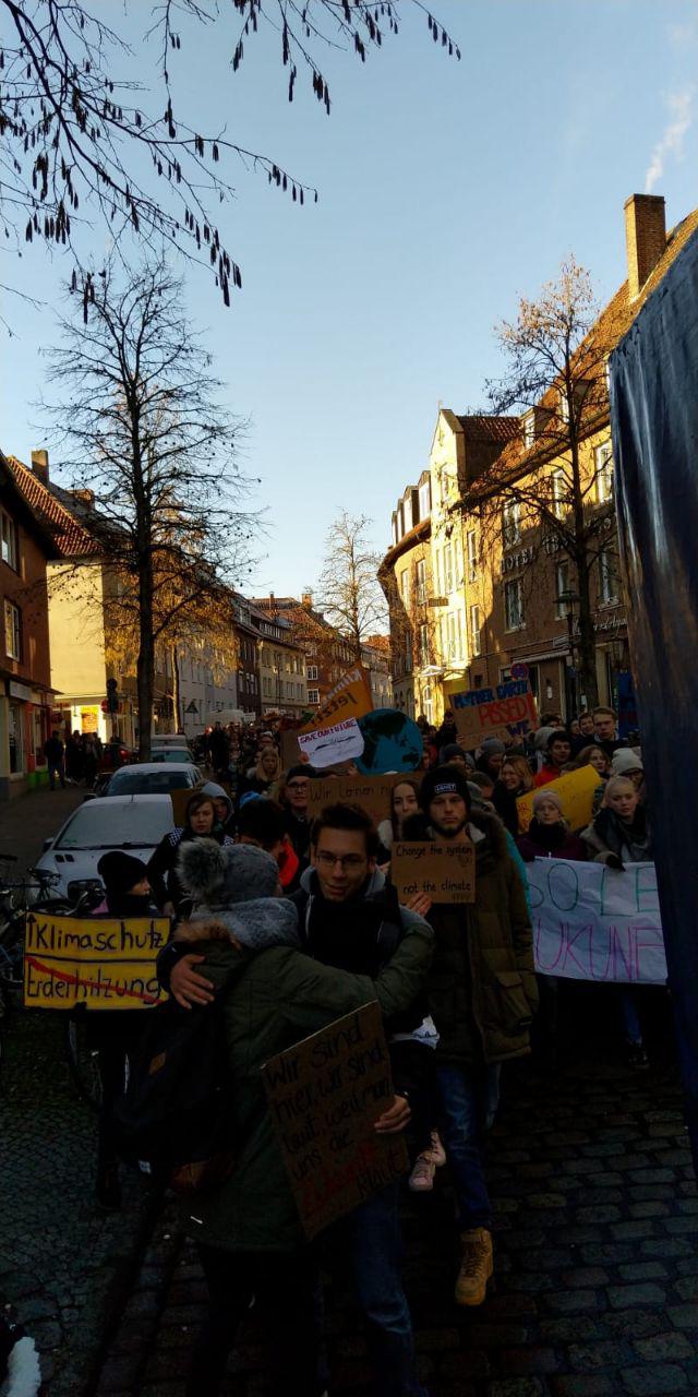 Viele Menschen mit Plakaten laufen durch eine Straße