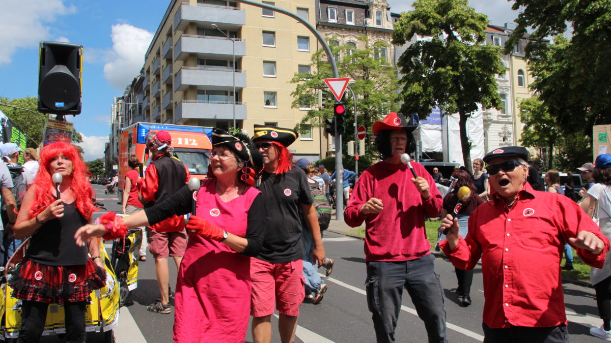 Eine bunt gekleidete Band macht Musik auf der Straße