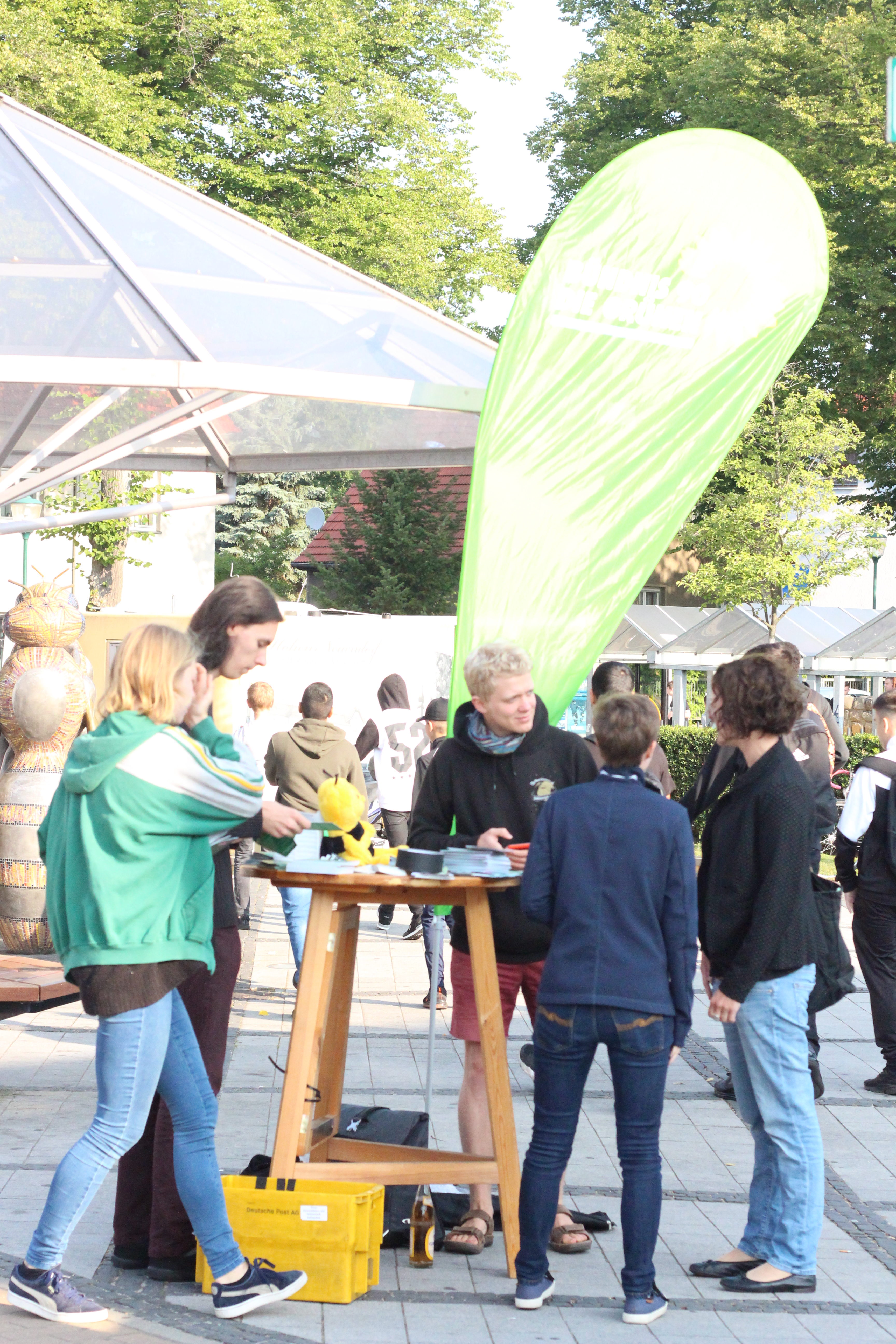 Mehrere Personen stehen an einem Wahl·kampf·stand und reden